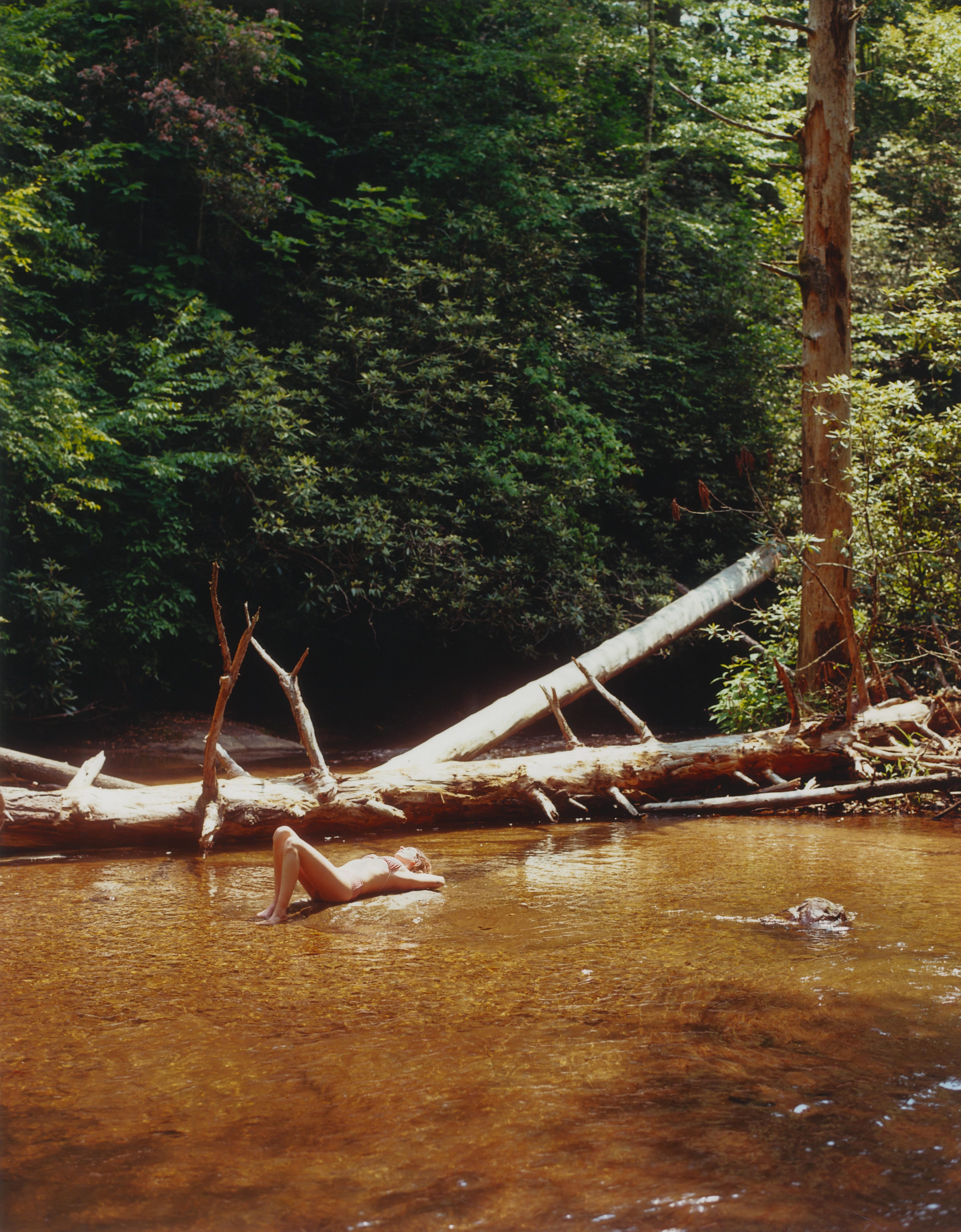 A woman sunbathes in the shallow water of Helton Creek in the Chattahoochee National Forest.