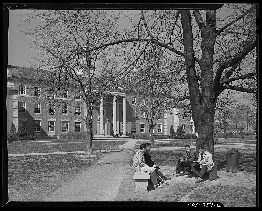 Archival photo of students sitting on campus at Howard.